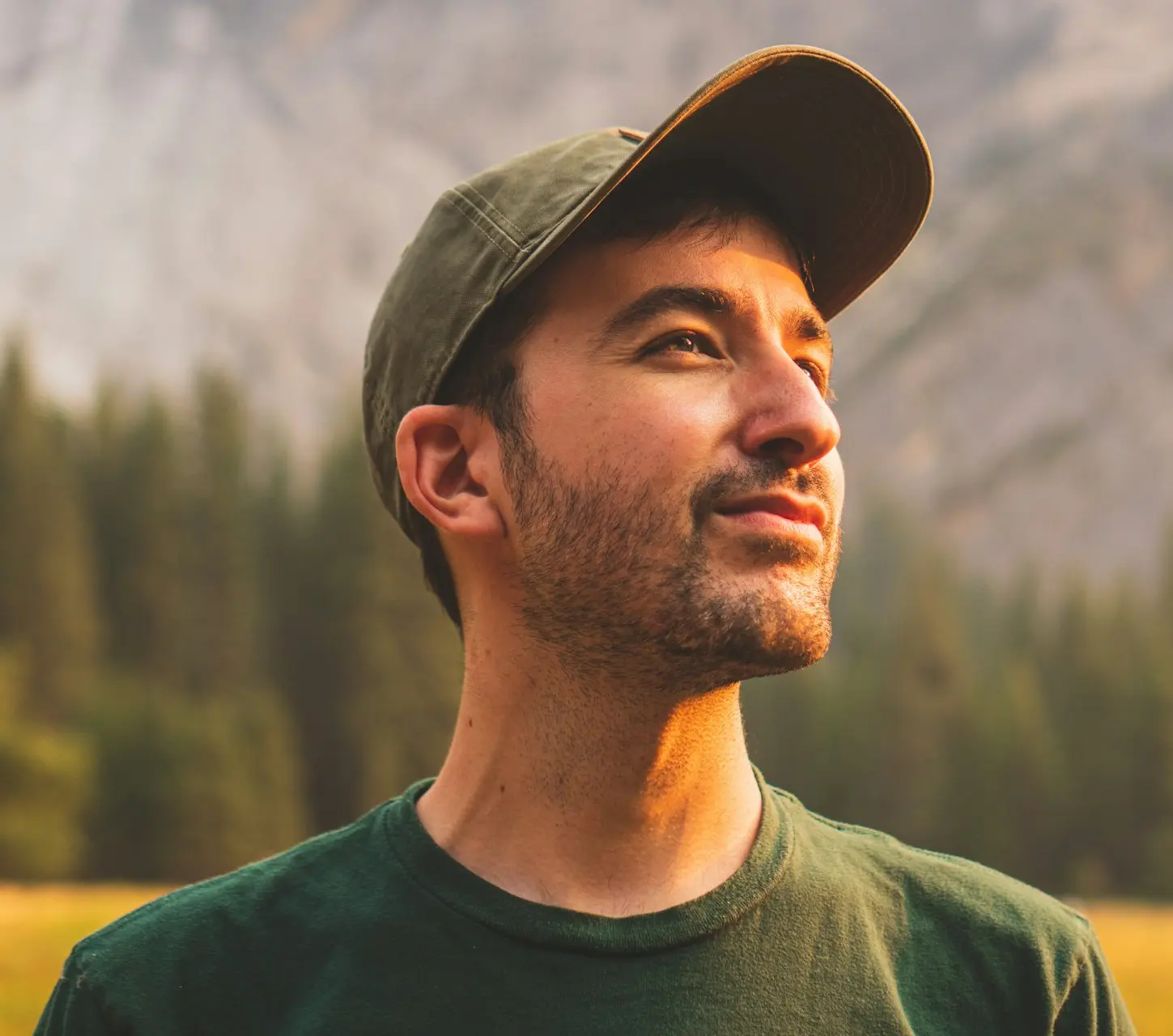 man in green crew neck shirt and black hat